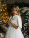 Teter Warm Dakota faux fur jacket worn by a young girl over a white dress in a festive setting.