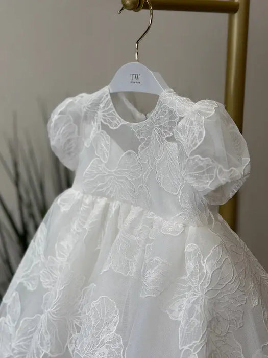 Teter Warm Dalia Floral Off-White Baptism Dress with puffy sleeves hanging on a white hanger.