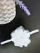 Teter Warm elegant white baby girl headband with flower detail on a dark tabletop