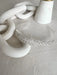 Eloise Rhinestone Tiara displayed on a light textured surface beside modern white decor.