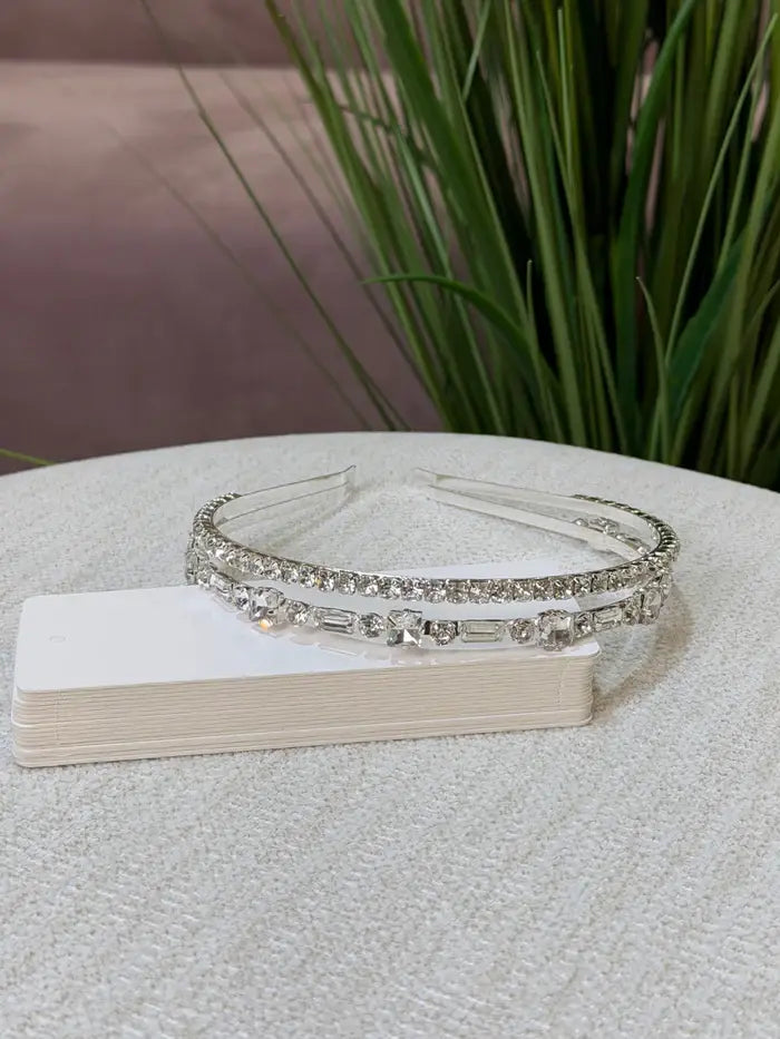 Teter Warm Emerald thick double band headpiece with sparkling crystals displayed on a fabric surface.