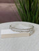 Teter Warm Emerald thick double band headpiece with sparkling crystals displayed on a fabric surface.