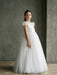 Teter Warm Emma Lace Communion Dress shown worn by a young girl standing indoors on a wood floor.