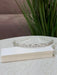 Teter Warm Gem Double Band Headpiece with sparkling crystals displayed on a table near green plants.