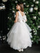 Off-white pearl communion dress with bow, shown on a girl standing by a decorated Christmas tree.