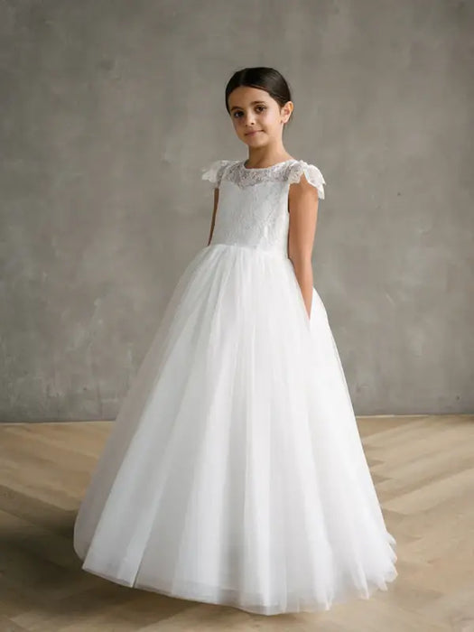 Teter Warm Gisele Lace Cap Sleeve Communion Dress shown on a girl standing indoors on wood flooring.