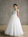 Teter Warm Gisele Lace Cap Sleeve Communion Dress shown on a girl standing indoors on wood flooring.