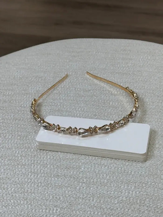 Teter Warm Goldie teardrop floral headpiece with crystal accents displayed on a textured surface.