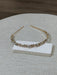 Teter Warm Goldie teardrop floral headpiece with crystal accents displayed on a textured surface.