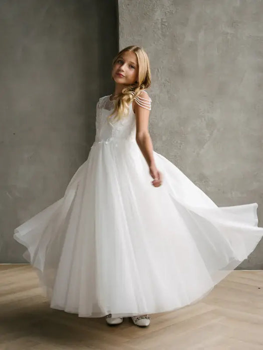 Hailey Lace Sequin Communion Dress shown on a girl standing indoors with flowing skirt detail.