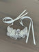 Teter Warm Hannah Pearl Headband with floral bead design and satin ribbons on a wooden surface.