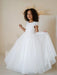 Heidi Sequin Bodice Communion Dress shown worn by a young girl posing indoors against a neutral background.