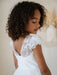 Heidi Sequin Bodice Communion Dress with floral embroidered sleeves worn by a young girl indoors.