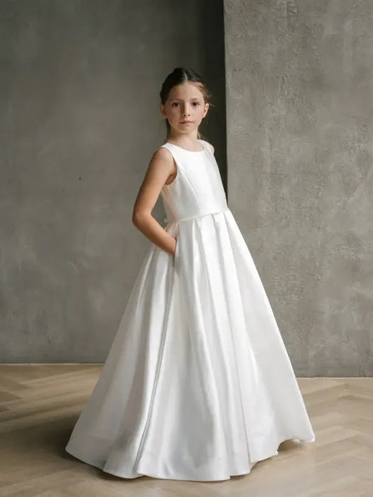 Teter Warm Isabella off-white satin communion dress worn by a girl standing indoors