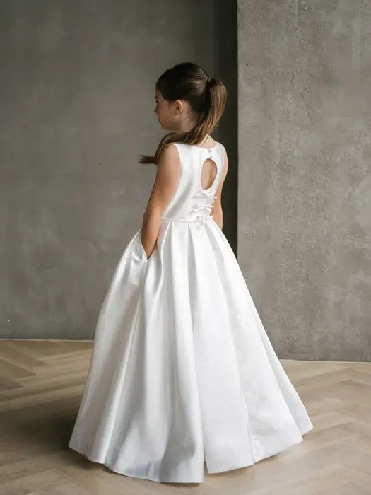 Teter Warm Isabella off-white satin communion dress shown on a young girl standing indoors