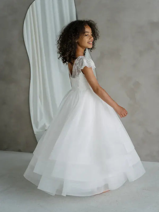 Teter Warm Lenni off-white communion dress with lace sleeves worn by a girl in a studio setting.