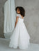 Teter Warm Lenni off-white communion dress with lace sleeves shown on a girl standing indoors.