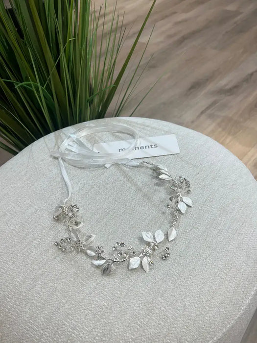 Teter Warm Leslie silver rhinestone headpiece with leaf and floral design displayed on a light fabric surface.