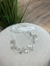 Teter Warm Leslie silver rhinestone headpiece with leaf and floral design displayed on a light fabric surface.
