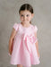 Teter Warm Lettie pink party dress with large bow, worn by a young girl against a neutral background.
