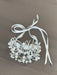 Lillian Pearl Double Band Headpiece with floral and pearl details, displayed on a wood surface.