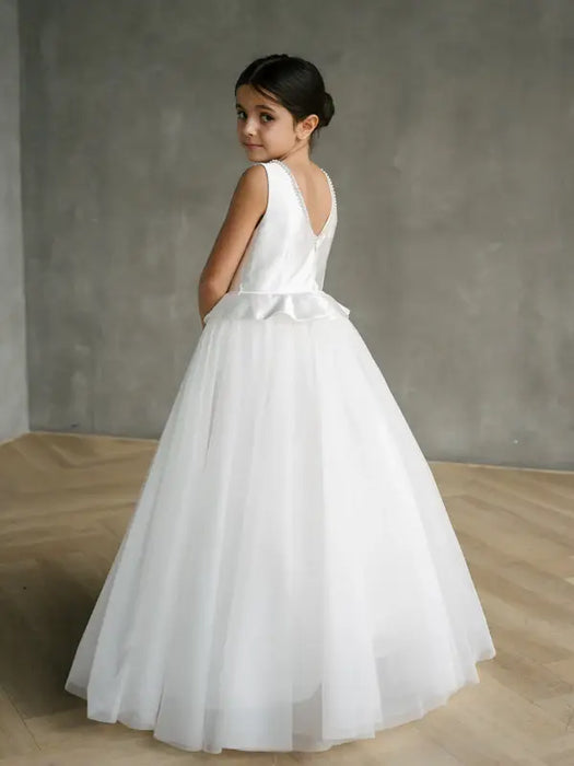 Teter Warm Liza Satin Communion Dress shown on a young girl standing in a minimalist room.