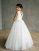 Teter Warm Liza Satin Communion Dress shown on a young girl standing in a minimalist room.