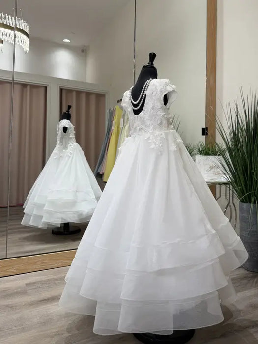 Teter Warm Marietta communion dress displayed on a mannequin in a boutique with mirrored walls.