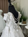 Teter Warm Marietta communion dress with floral lace and pearls displayed on a mannequin indoors.