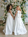 Teter Warm Penelope off-white communion dresses on two girls standing in front of floral backdrop.