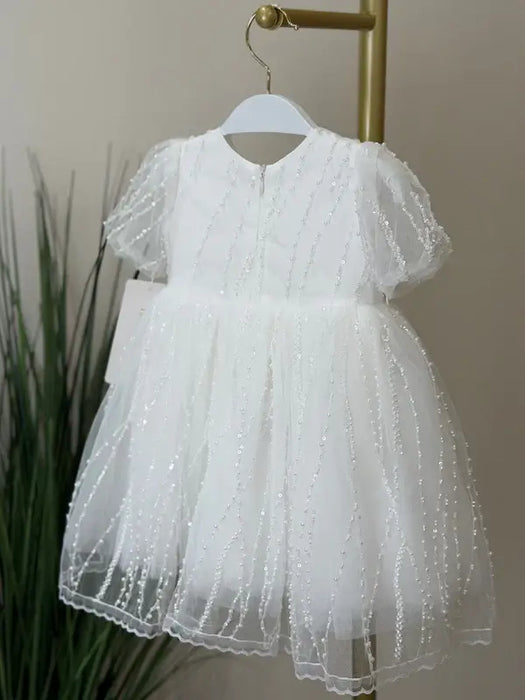 Teter Warm Perla off-white sequin baptism dress with short sleeves hanging on a rack.