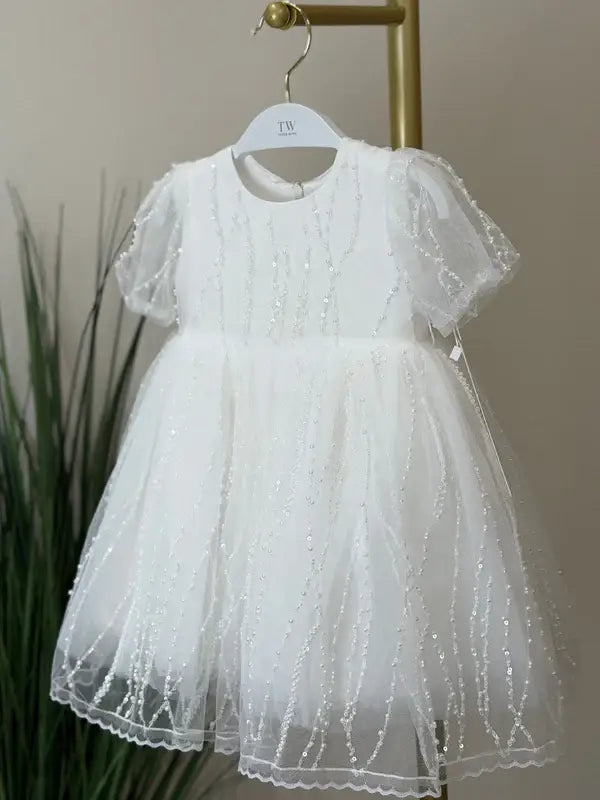 Teter Warm Perla Off-White Sequin Baptism Dress displayed on a hanger against a neutral background.