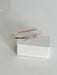 Teter Warm Polli rose gold headband with crystal bow displayed on a white box against a plain background.