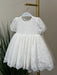 Teter Warm Precious Lace Baptism Dress displayed on a hanger with puff sleeves and floral lace details.