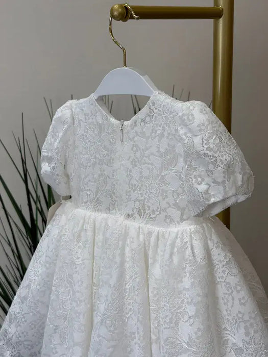 Teter Warm Precious Lace Baptism Dress displayed on a hanger, featuring delicate white lace detail.