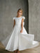 Teter Warm Quinn Satin Communion Dress shown on a young girl standing indoors, dress flowing elegantly.