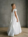 Teter Warm Quinn Satin Communion Dress shown on a young girl with lace sleeves and a large back bow