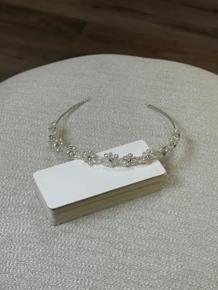 Teter Warm Rebel Pearl Headpiece with floral pearl accents displayed on a textured fabric surface.