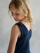 Teter Warm Reese dark sleeveless party dress shown on a young girl with blonde hair, rear view.
