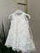 Teter Warm Rosalyn off-white floral lace baptism dress displayed on a hanger indoors.