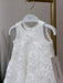 Teter Warm Rosalyn off-white floral baptism dress hanging on a white hanger against a neutral background.