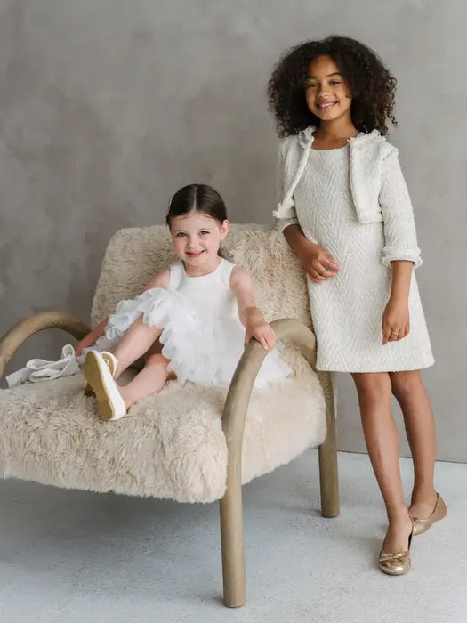 Teter Warm Sakura Girls Tweed Cropped Jacket shown on a girl standing in a cream dress beside a seated child.