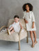 Teter Warm Sakura Girls Tweed Cropped Jacket shown on a girl standing in a cream dress beside a seated child.