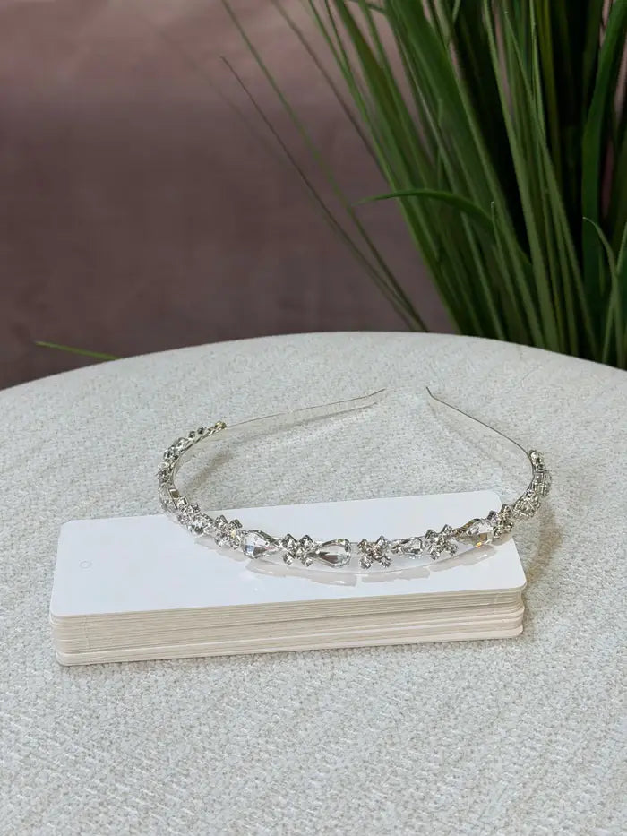 Teter Warm Solver Teardrop Headpiece with clear crystals displayed on a white box on a fabric surface.