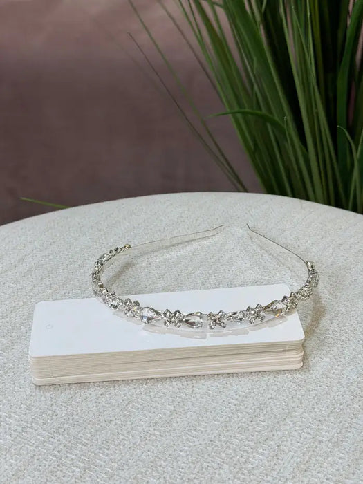Teter Warm Solver Teardrop Headpiece with clear crystals displayed on a white box on a fabric surface.