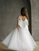 Teter Warm Sylvia Satin Pearl Communion Dress shown on a girl with a large bow in a minimal studio setting.