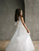 Sylvia Satin Pearl Communion Dress shown on a girl standing indoors with a tulle skirt and bow back.