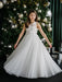 Teter Warm Thea off-white communion dress worn by a girl standing by a decorated Christmas tree.