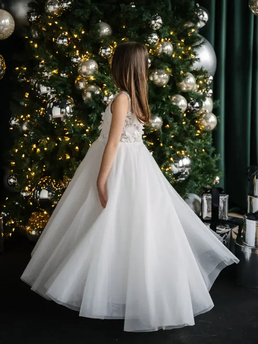 Teter Warm Thea Off-White Communion Dress worn by a girl standing beside a decorated Christmas tree.