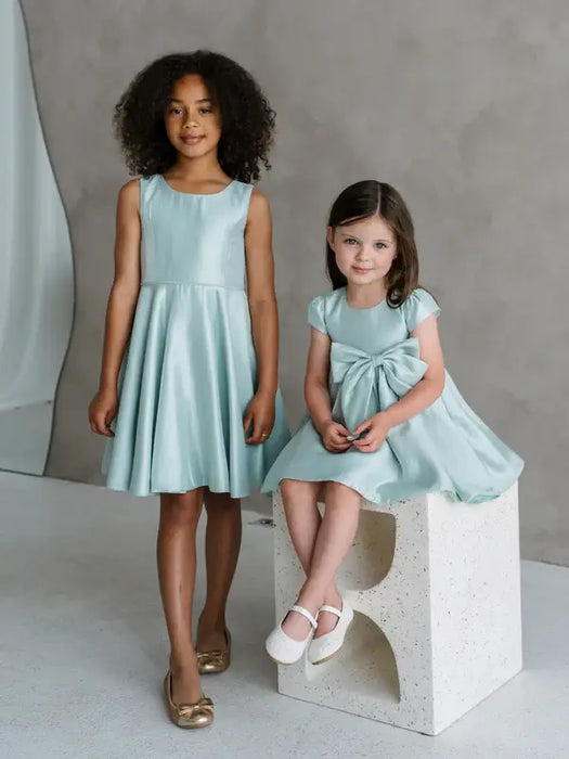 Teter Warm Tiffany Blue sleeveless party dresses on two young girls in a studio setting.